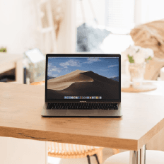 Laptop on a wooden table with a home interior background