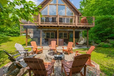 Cabin exterior with a fire pit and Adirondack chairs