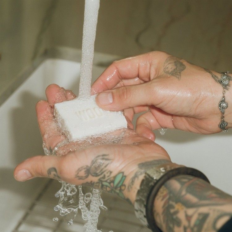 A man with long hair is working on a computer.