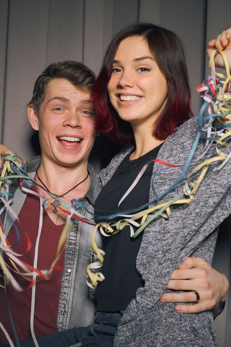 Married couple wearing photo booth props.
