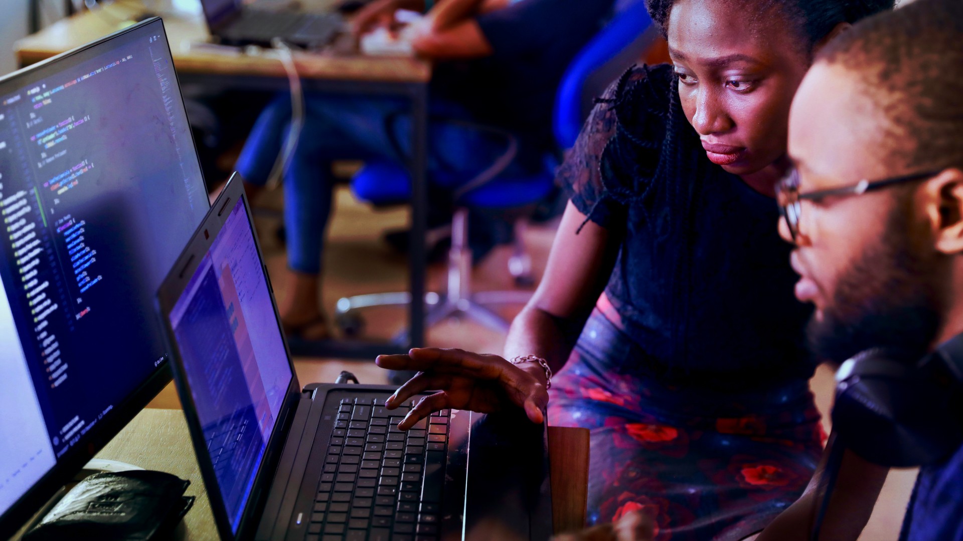 Two people work together at a laptop