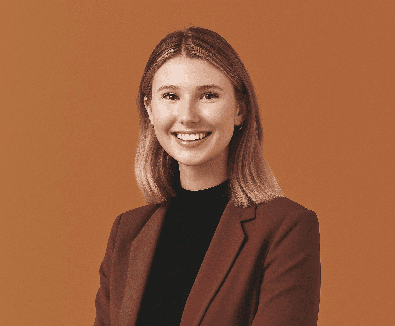 Smiling woman in a blazer and black shirt against a solid brown background.