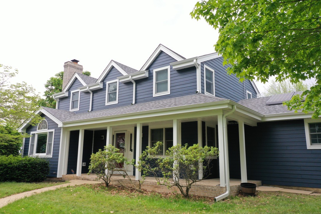 Original Top Quality Roofing project photo showing a suburban Illinois home with professionally installed lap siding. Used as the featured image for an article comparing siding materials and winter performance for Illinois homes.