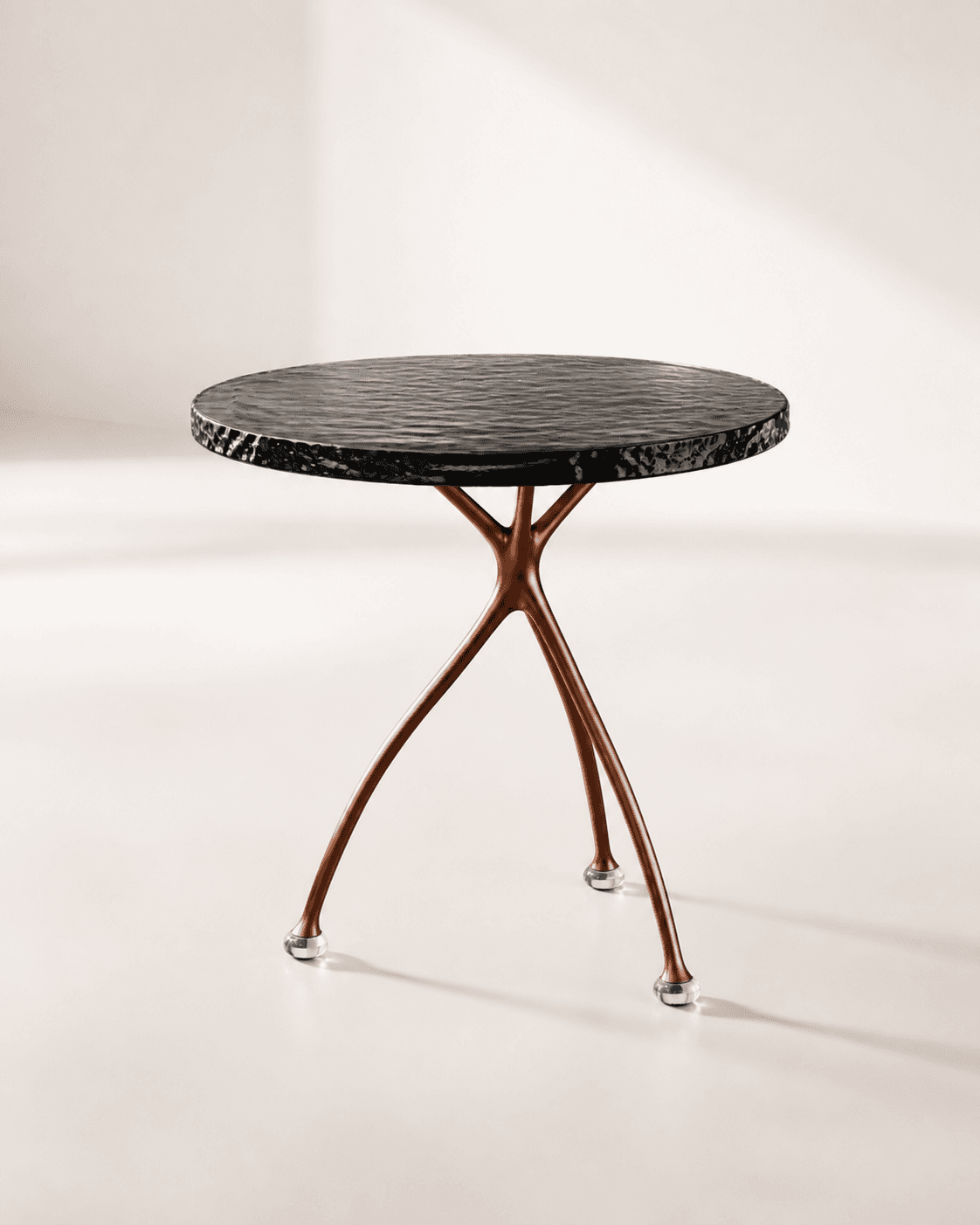 Tide Side Table, a rippled black-glass disc balanced on exactly three copper feet, photographed in a bright white studio