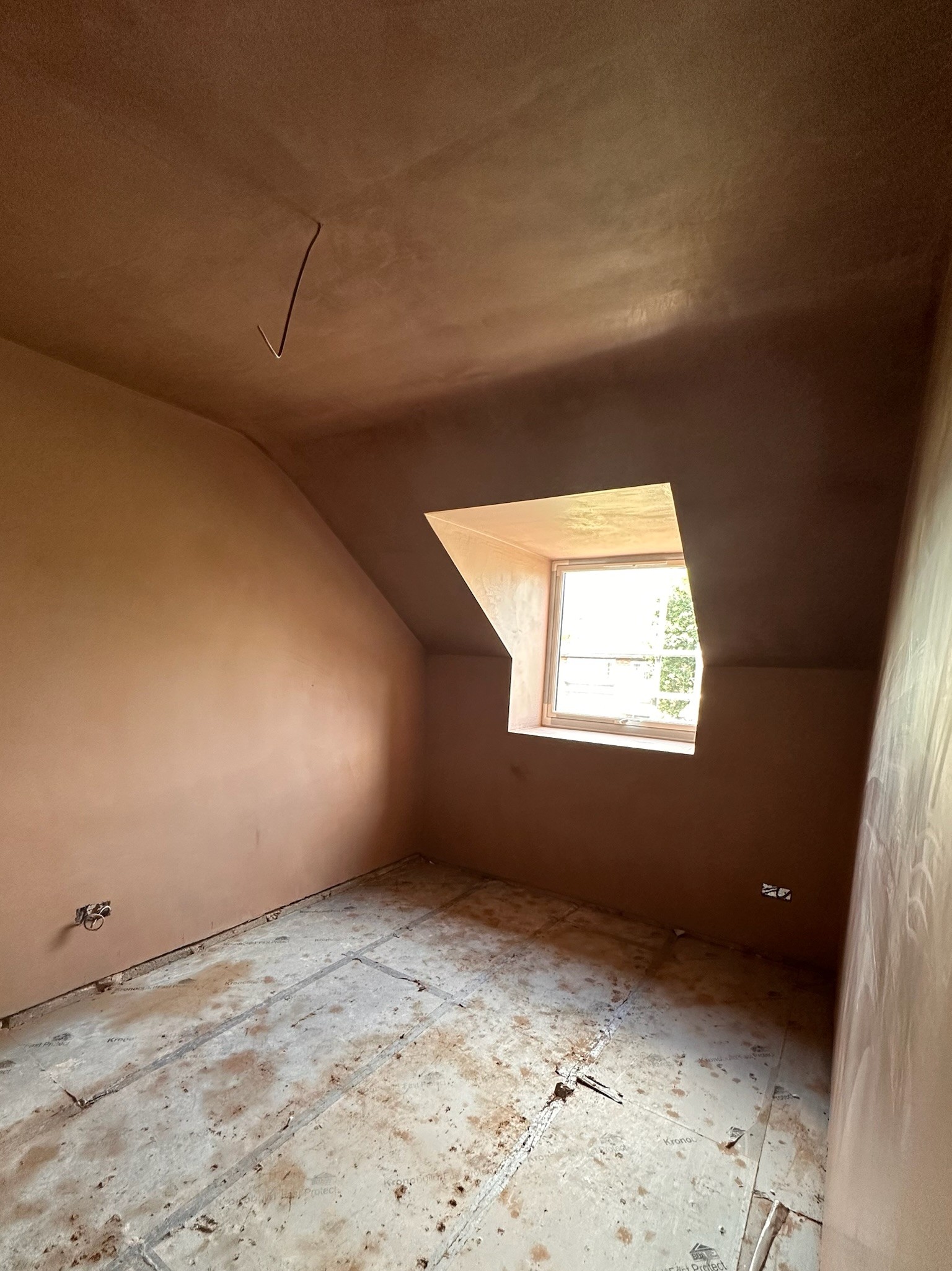 Vaulted plastered ceiling with window.