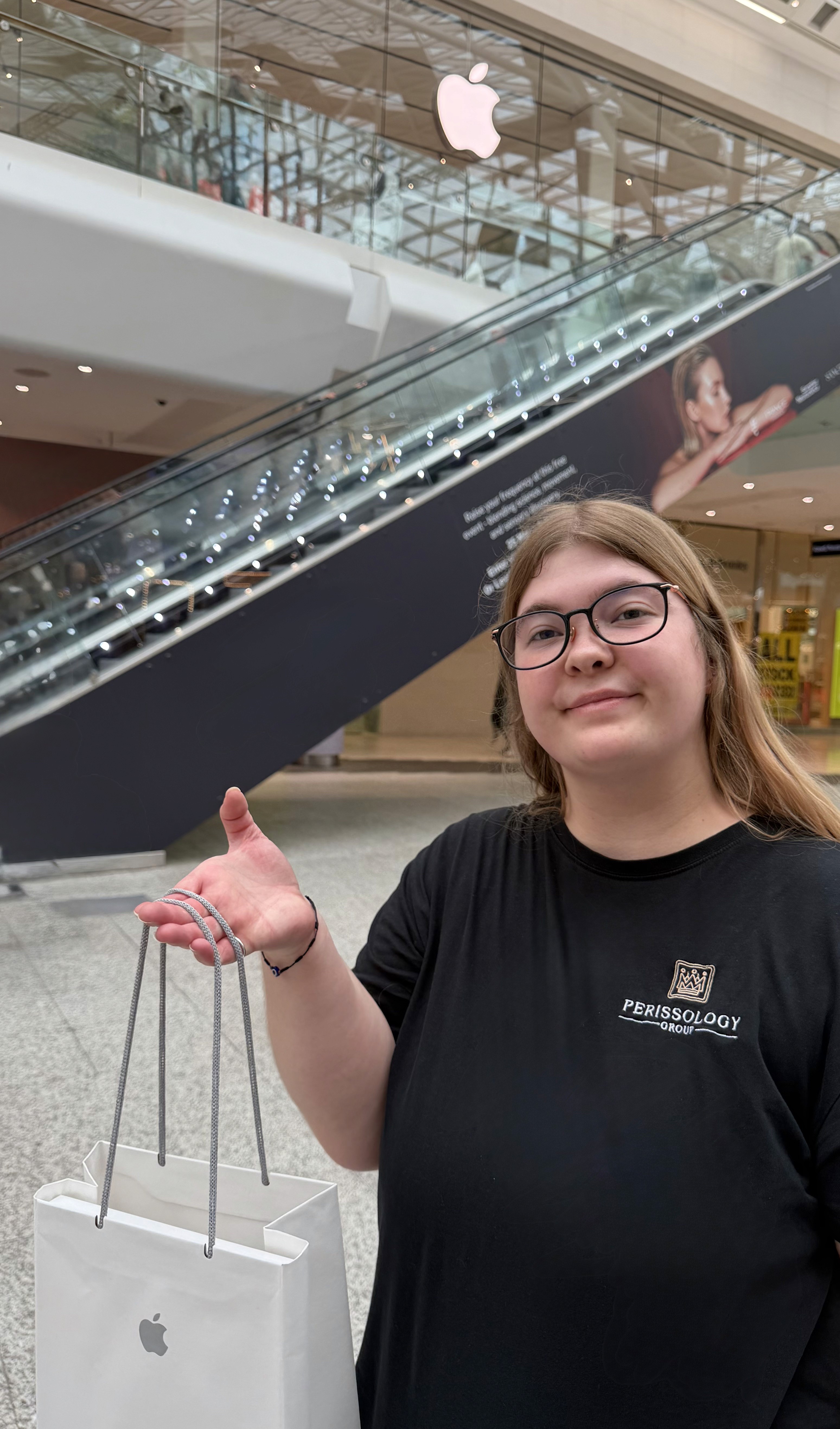 Perissology Courier Caitlin handling Apple tech products