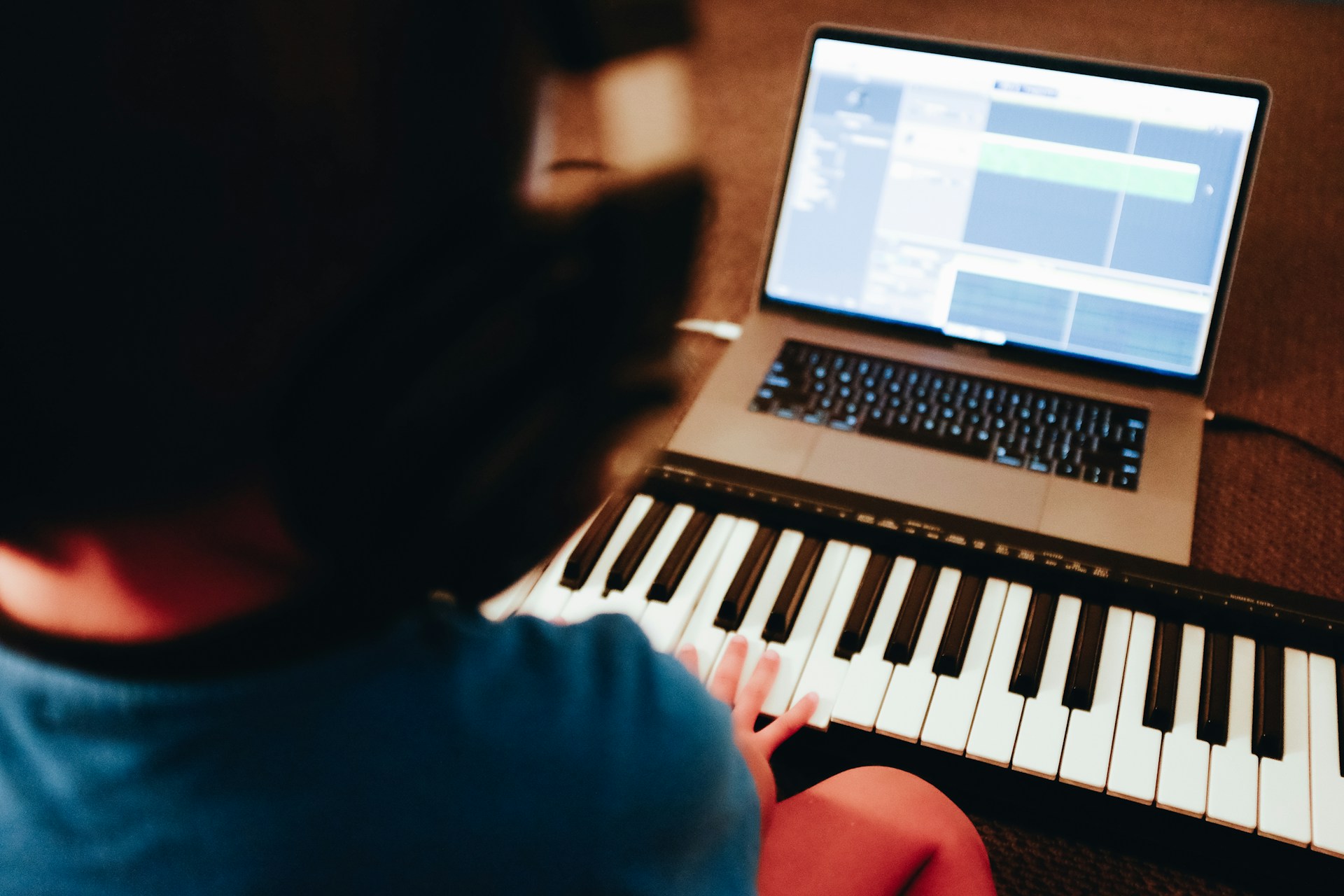person with piano and laptop - How to Make Instrumental Music