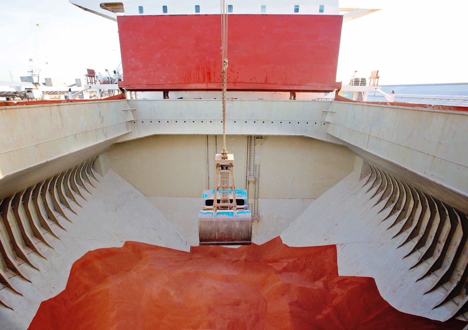Bulk carrier cargo hold during pre-loading inspection, showing clean structural surfaces, hopper tanks and loading grab positioning prior to dry bulk cargo operations.