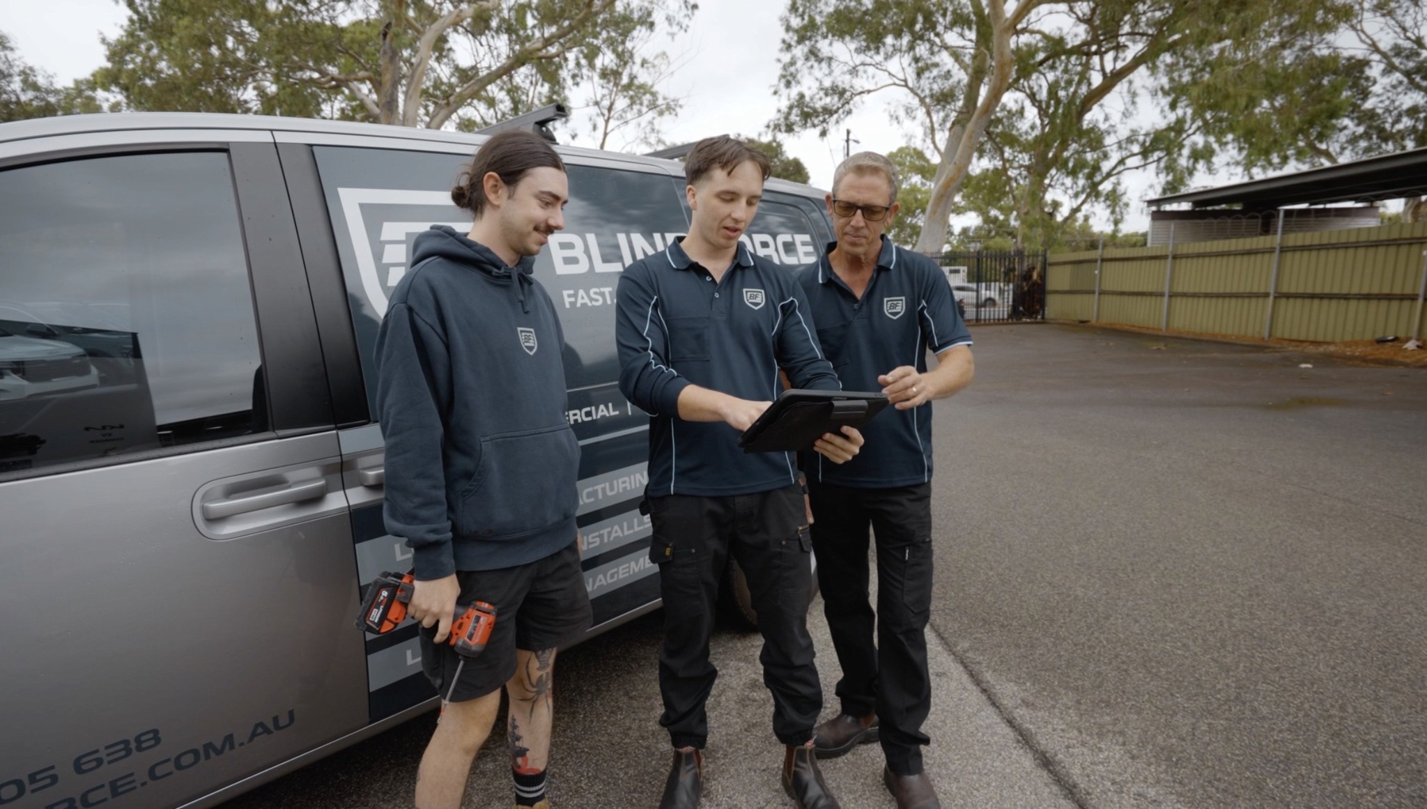 Team discussing job details while looking at iPad on site