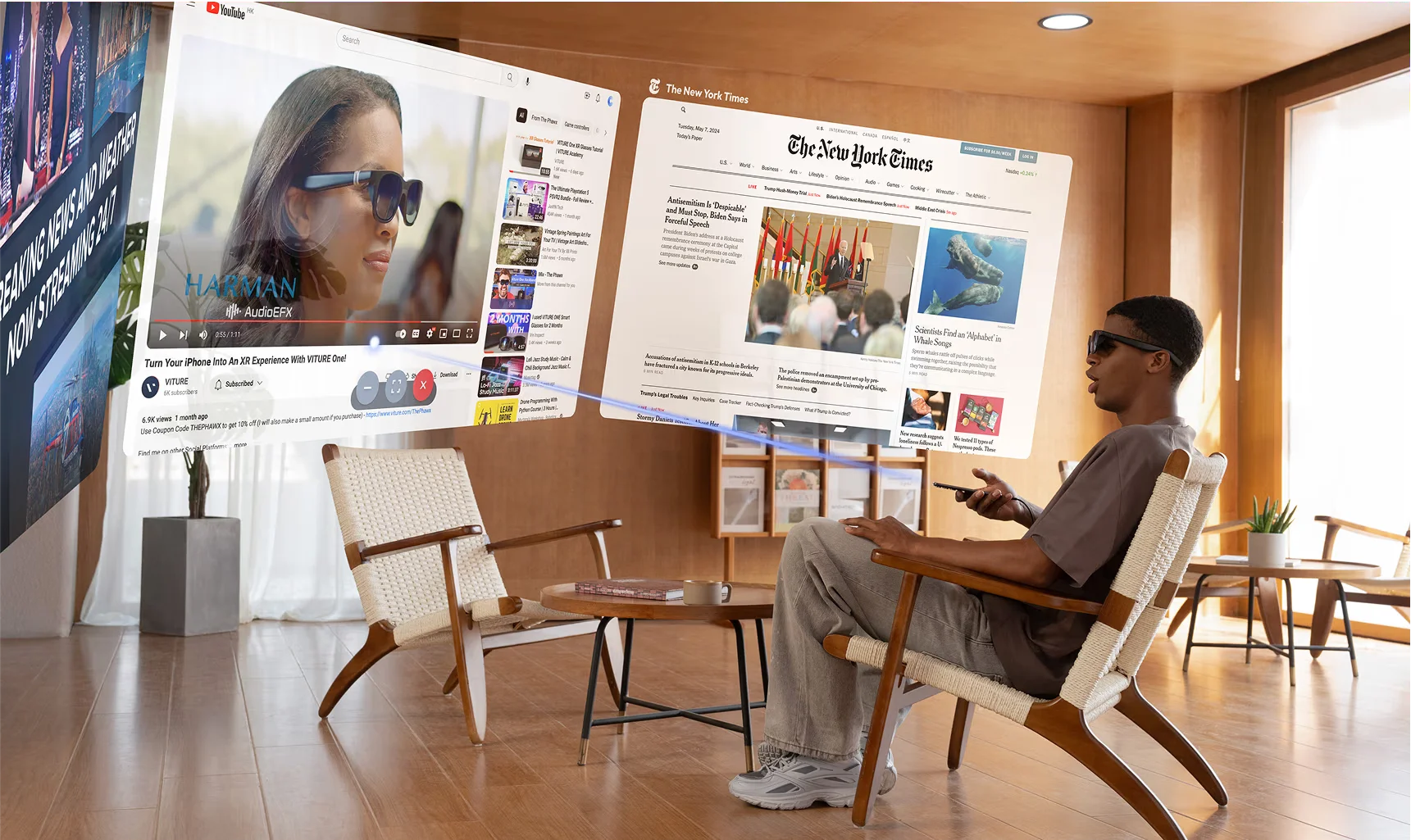 Man sitting in a bright modern living room wearing VITURE display glasses, viewing large floating virtual screens showing a YouTube video and a New York Times article in an immersive mixed reality desktop environment