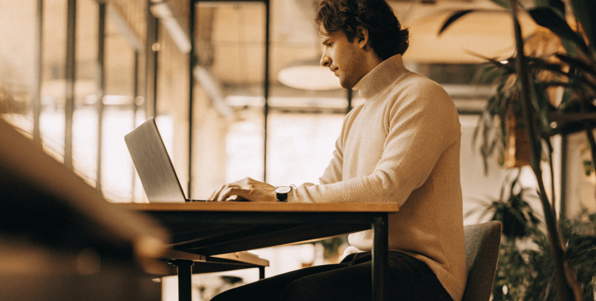 Designer working on laptop in bright office space