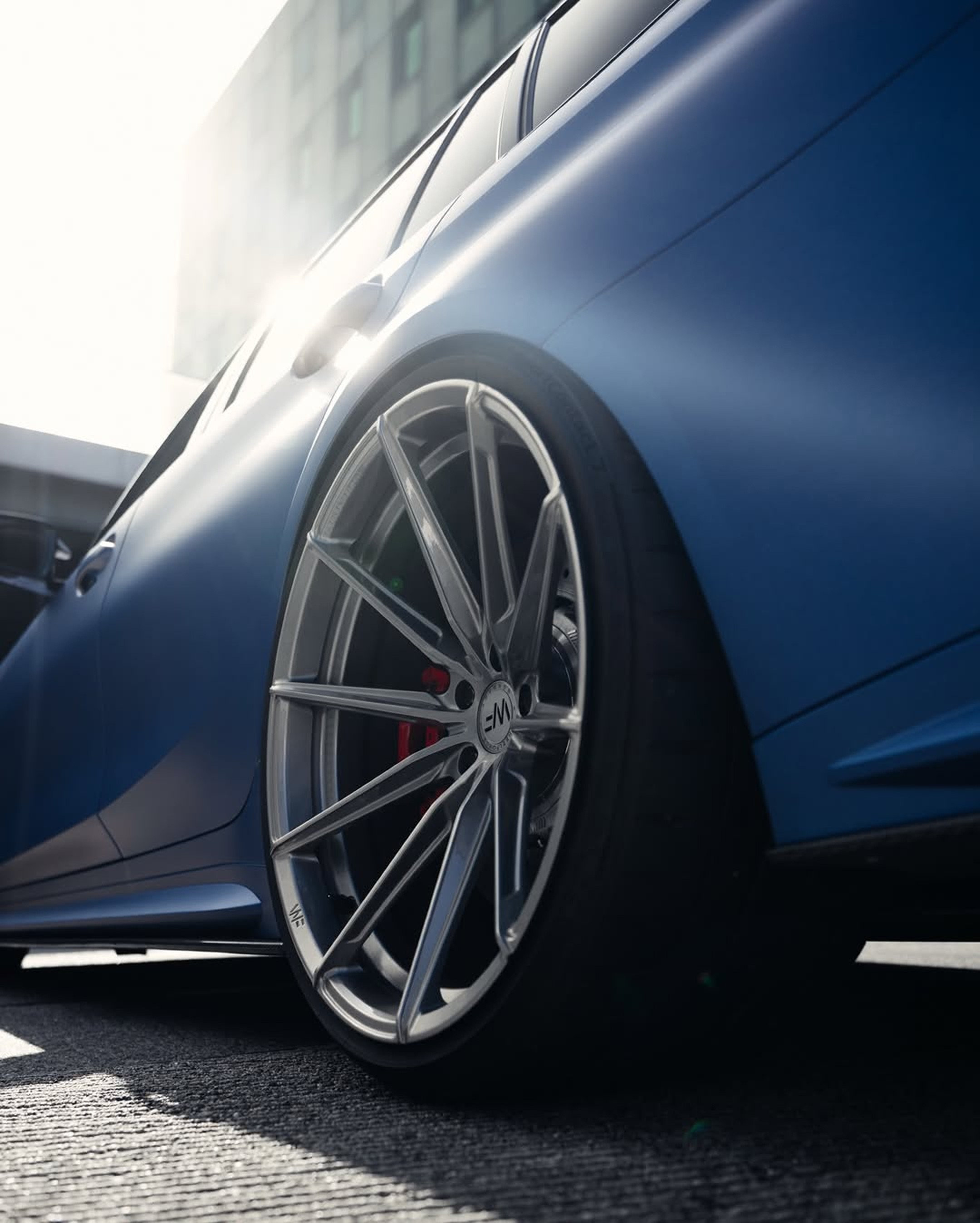 Jante avant d’une BMW M3 bleue mate en contre-plongée