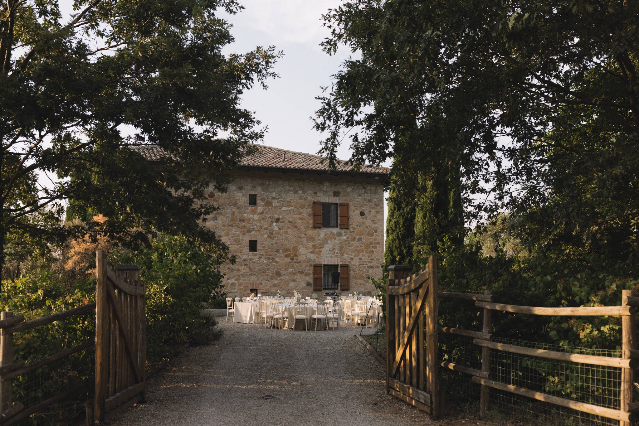 Cortile del Parco di Montebello con tavoli per ricevimento matrimoniale, circondato da alberi e architettura in pietra