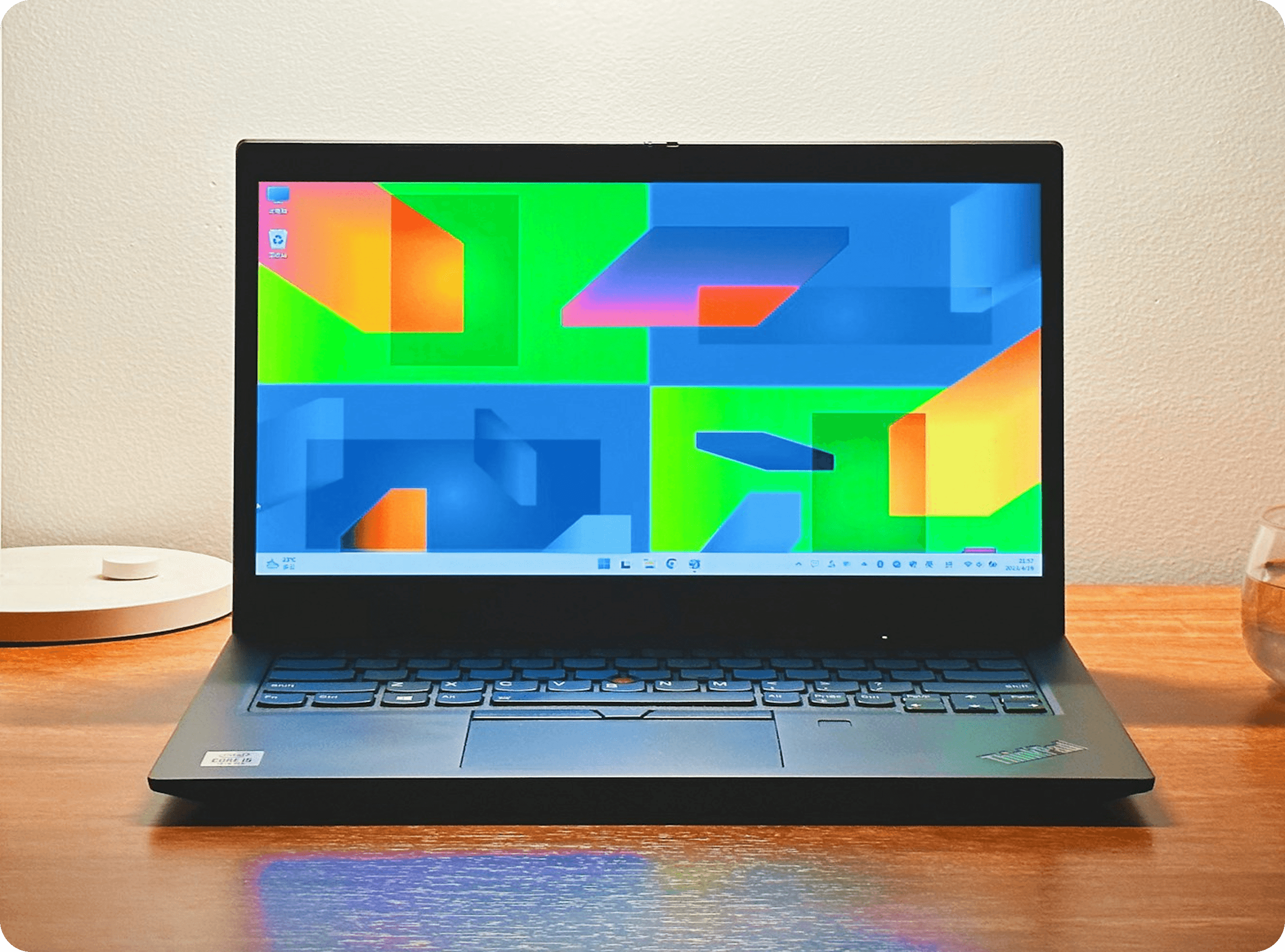 Laptop on a wooden desk with a colorful abstract screen.