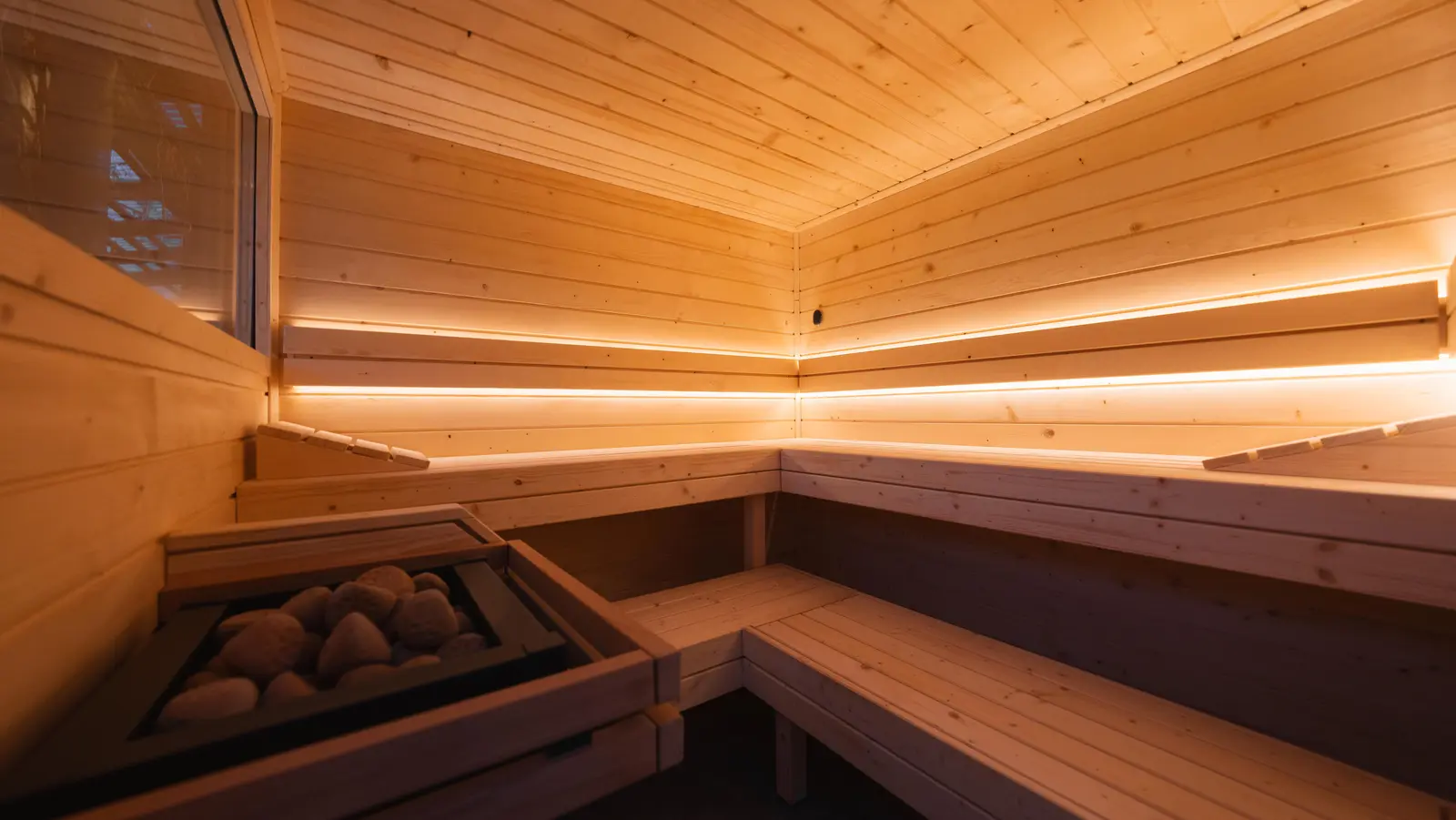 Sauna von innen mit aktiven Leuchten hinter den Rückenlehnen