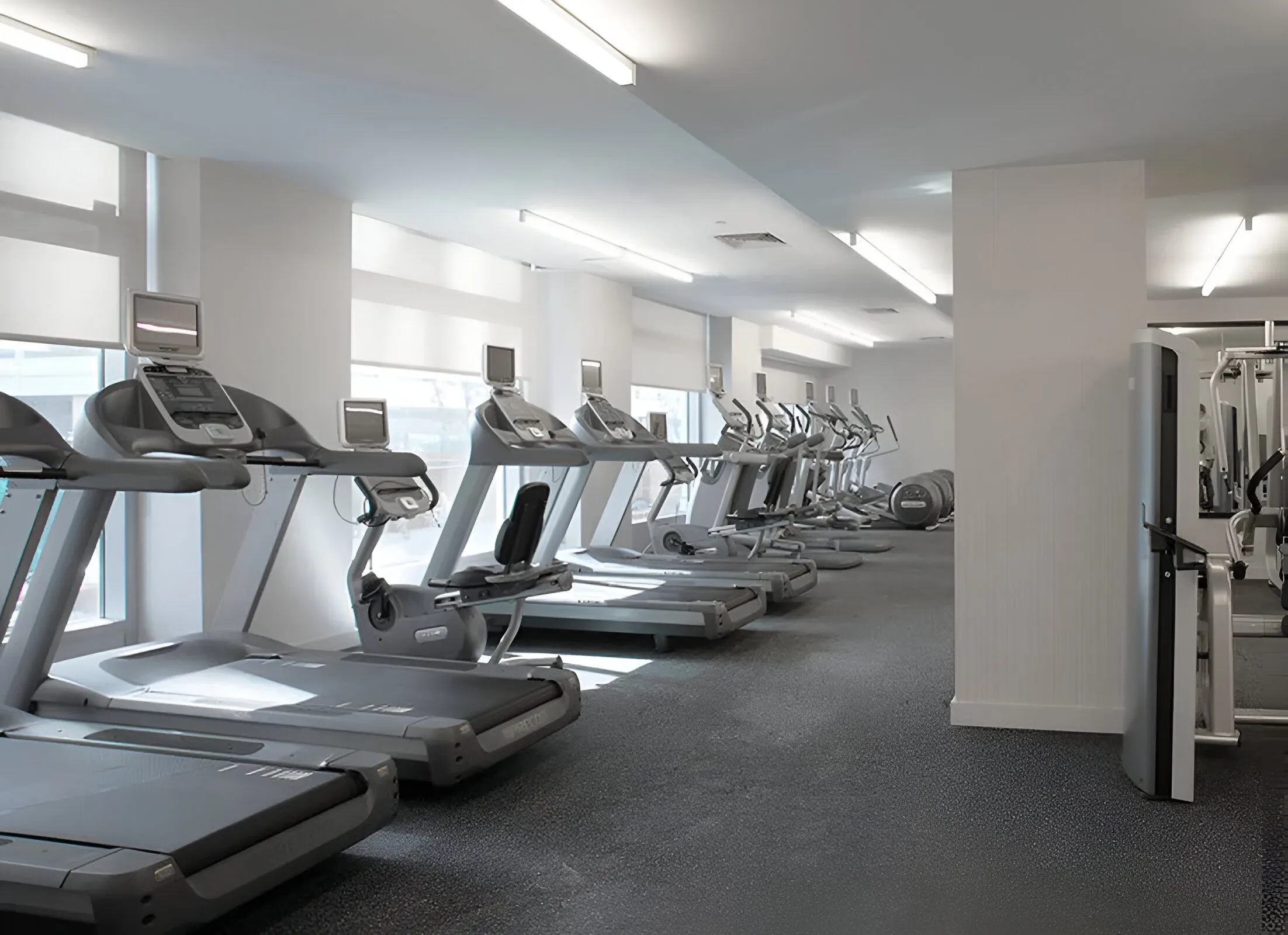 Interior of a gym showcasing treadmills and assorted exercise machines for fitness activities.