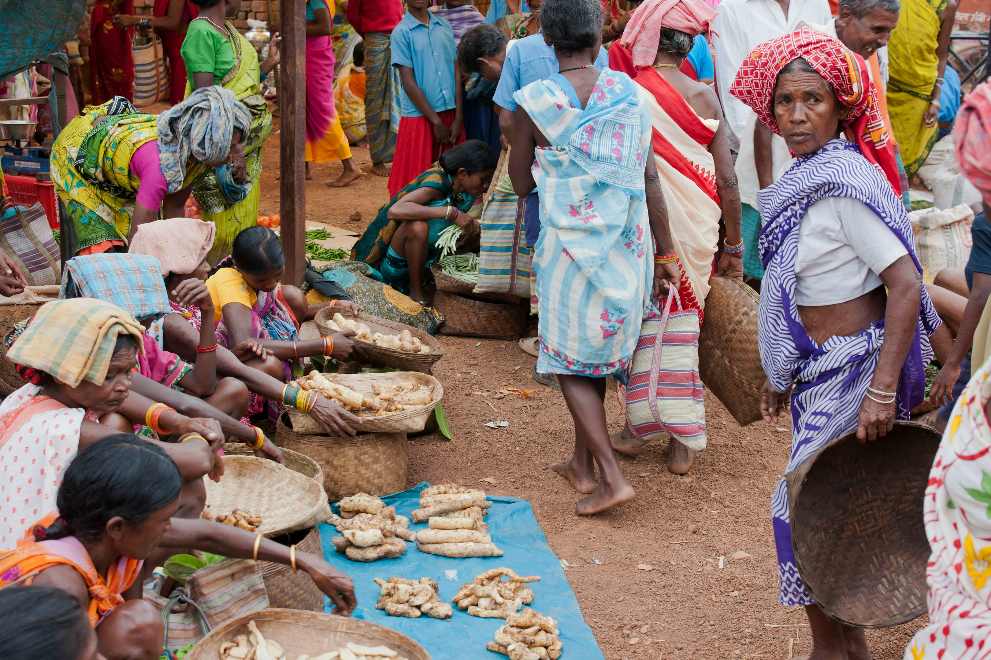 People selling produce at an outdoor market.