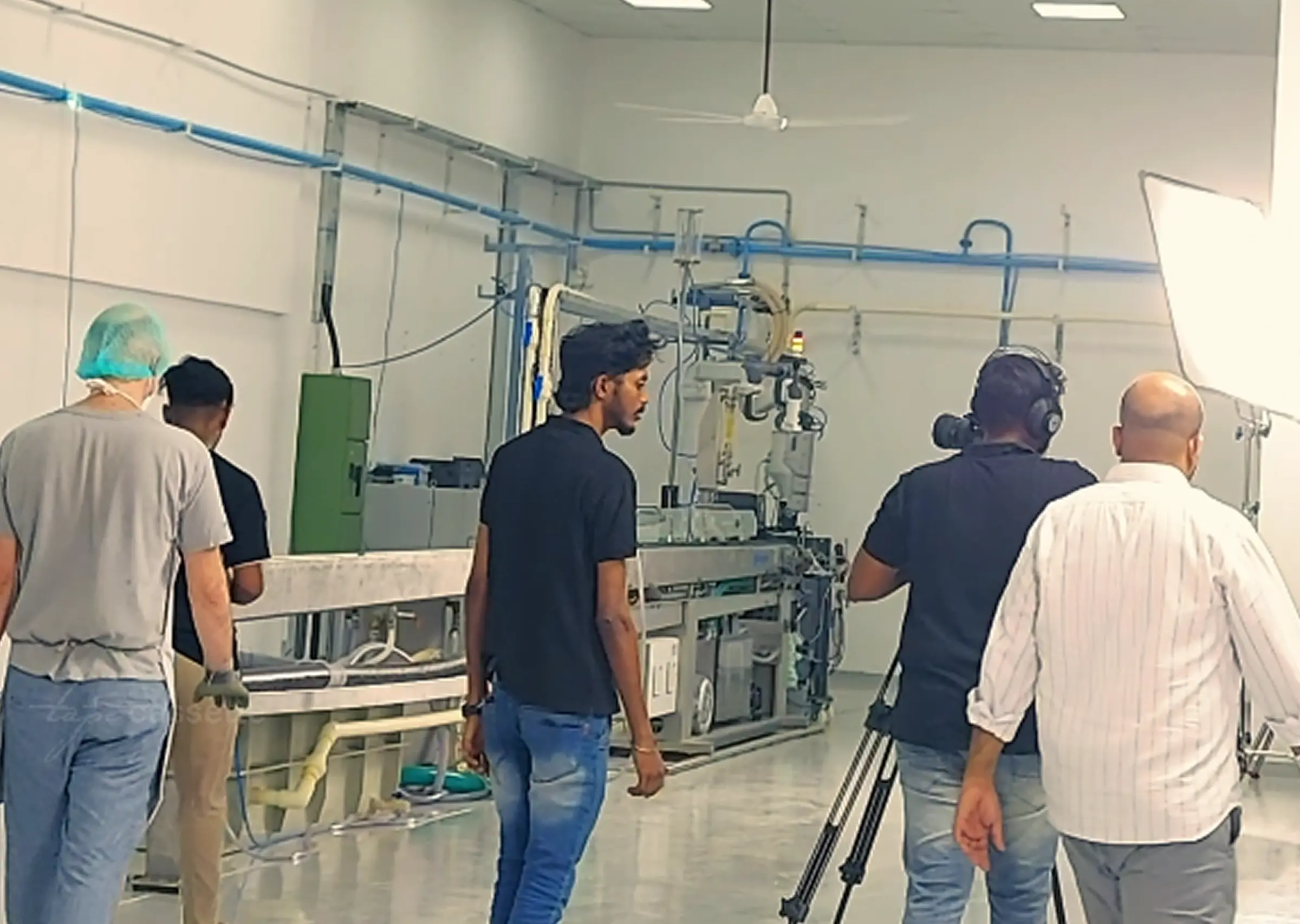 Video production crew setting up equipment and coordinating to capture test results in a lab setting