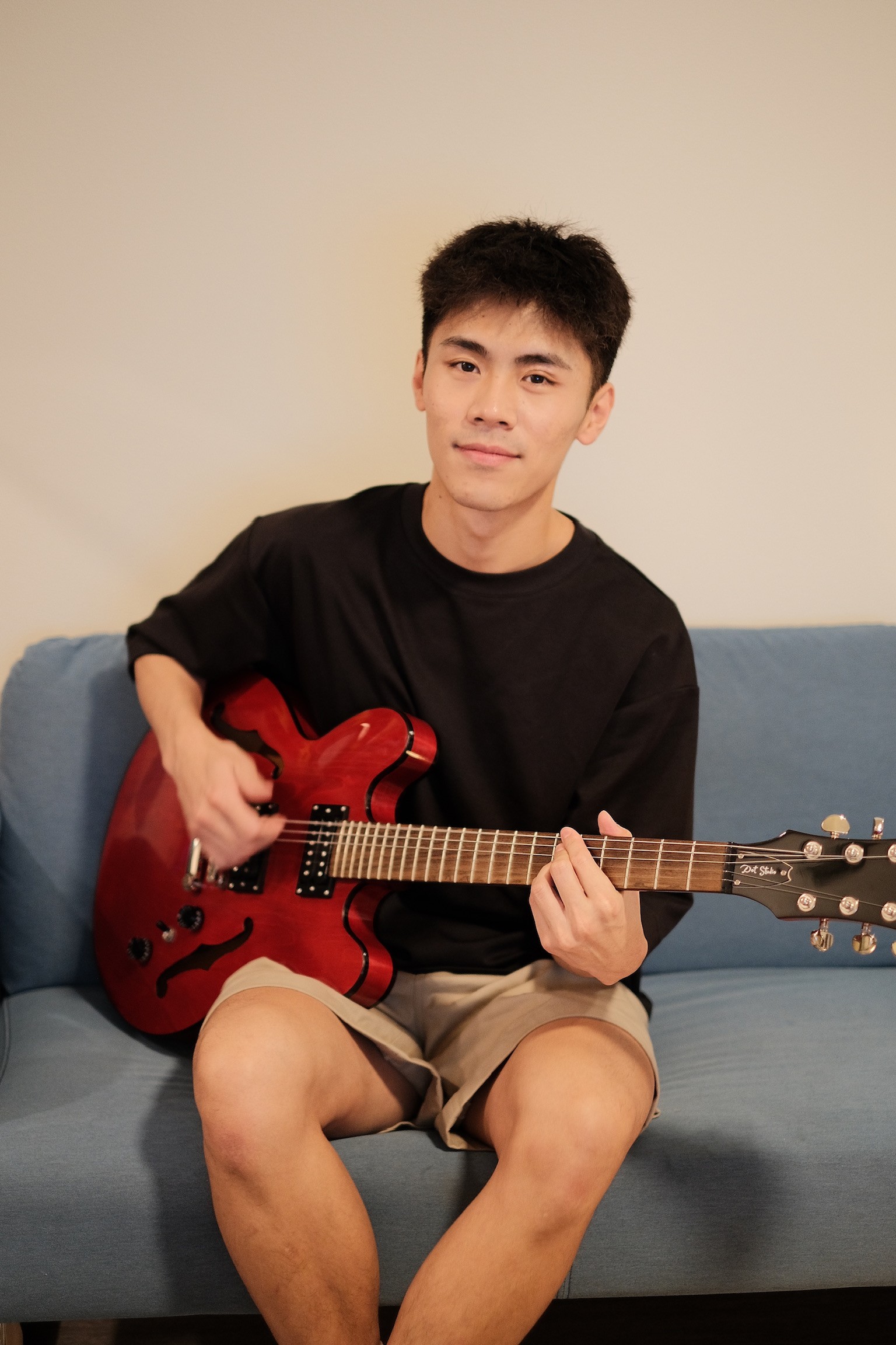 A thoughtful young person with dark hair gazes to the side, captured in soft black and white lighting.