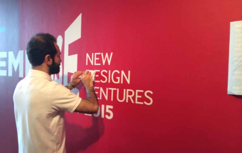 a man pressing vinyl letters on a red wall