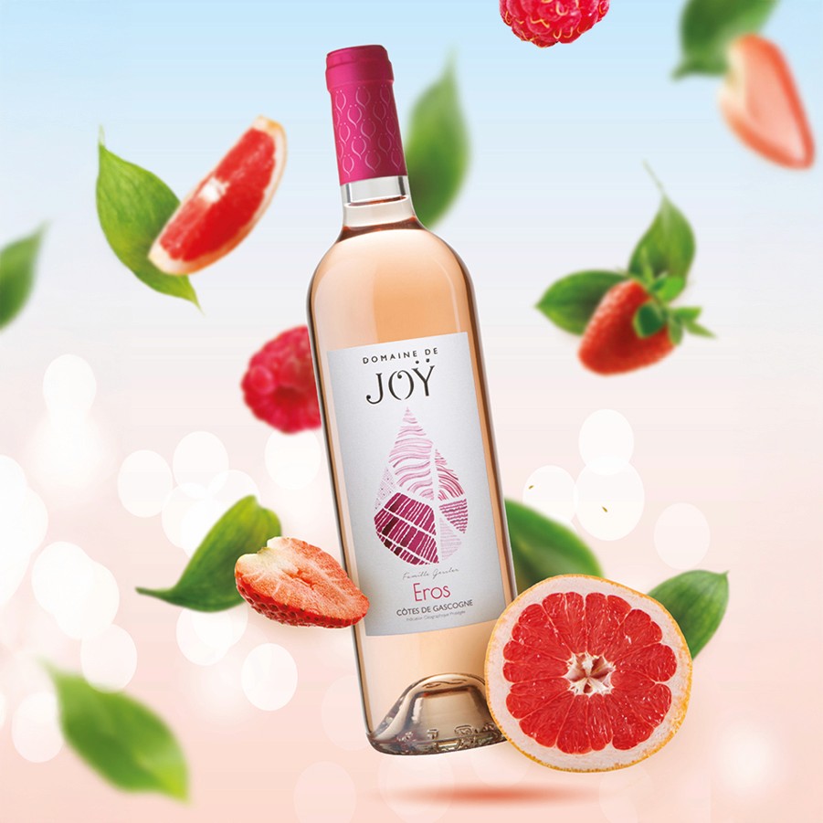 Affiche publicitaire colorée et fruitée pour le vin rosé Eros, gros plan sur la bouteille