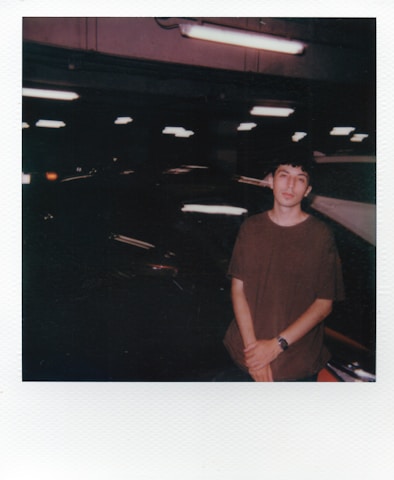Young man standing in parking lot at night