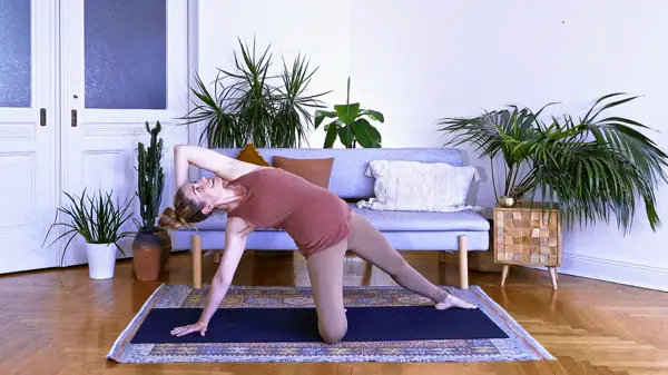 Pregnant woman in a standing yoga triangle variation with arm raised – Day 4 prenatal yoga class to destress and unwind using alternate nostril breathing