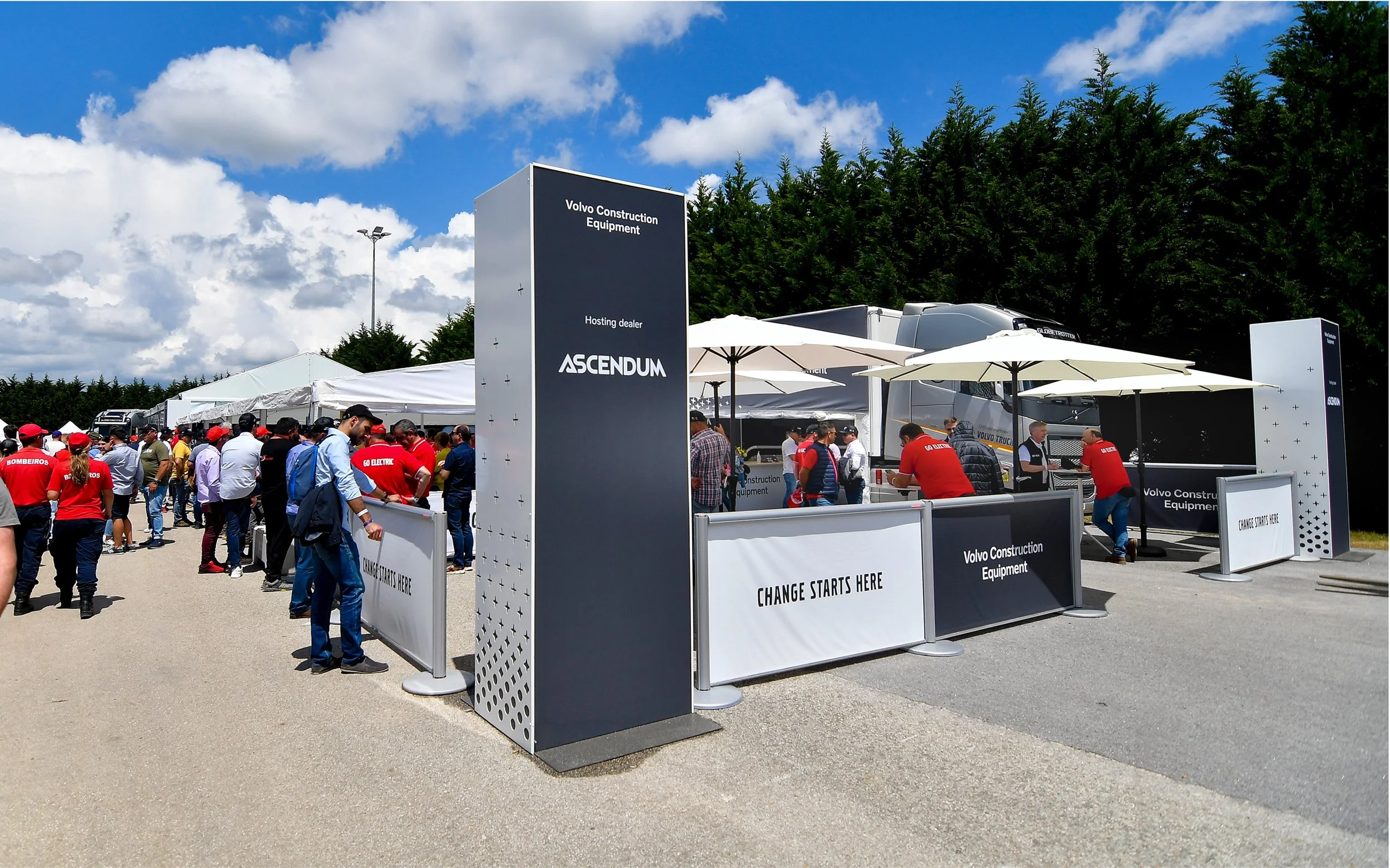 Ett evenemang utomhus med människor som står under parasoller i soligt väder