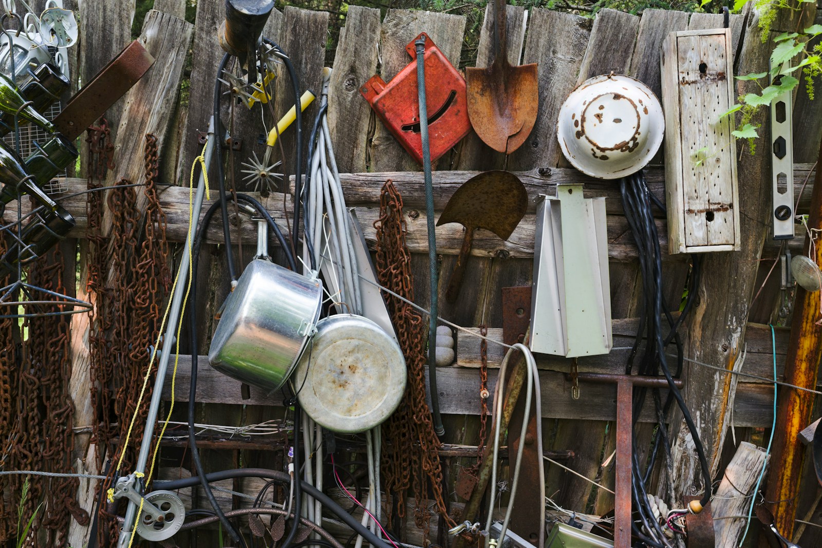 Backyard junk and tools hanging along a fence