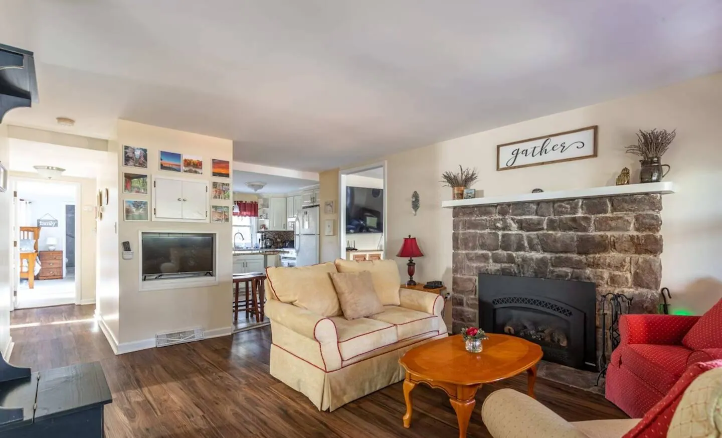 Open living room with stone fireplace, sofas and view to the kitchen at Relax in Style