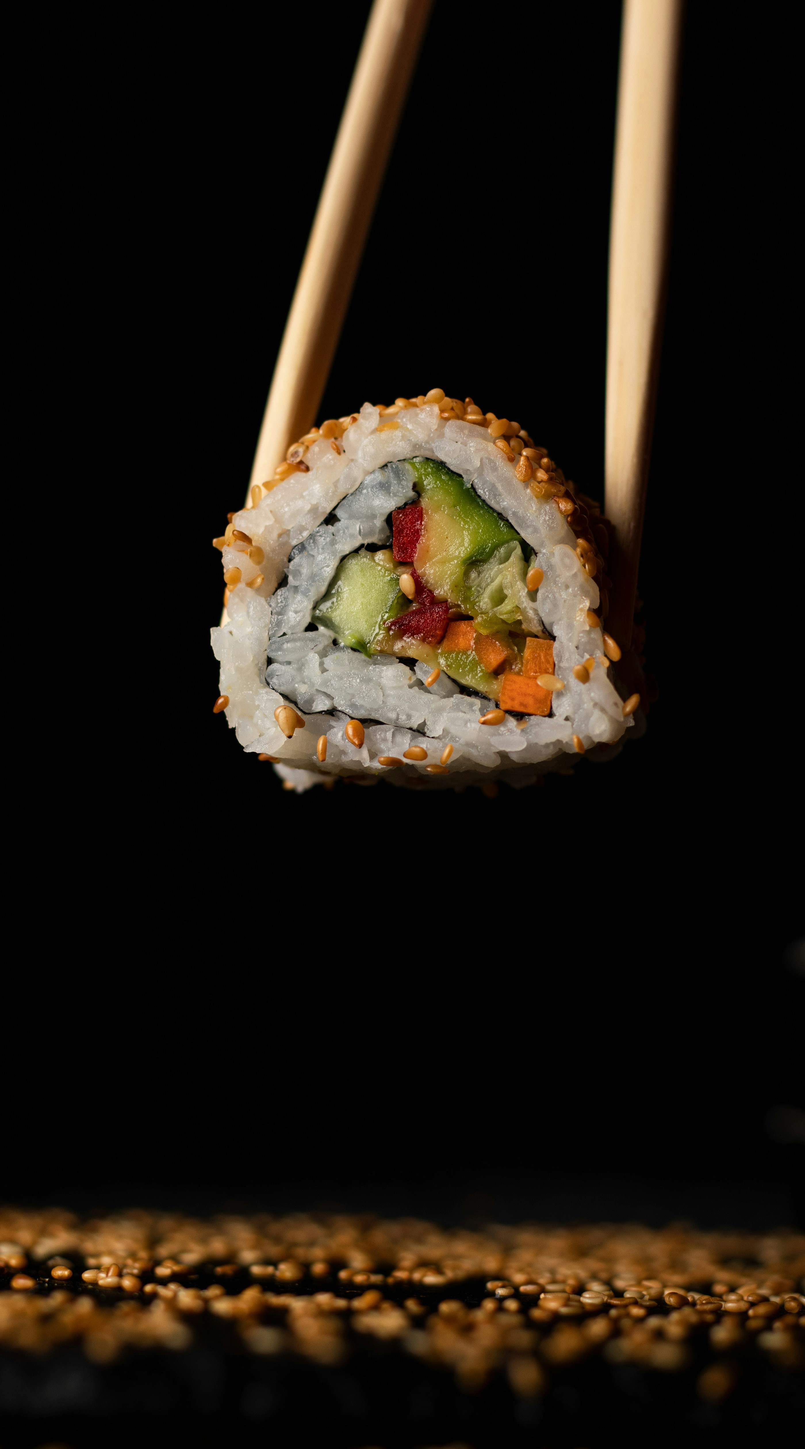 A close up of a sushi with chopsticks