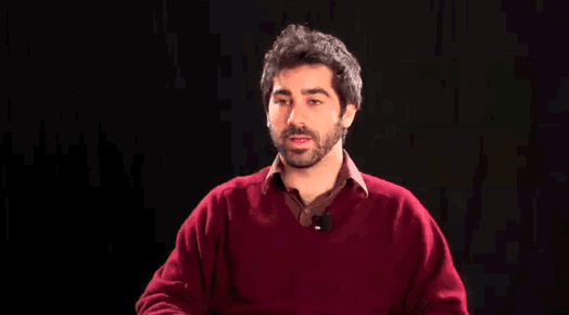A photo of a man in a red shirt on a black background.