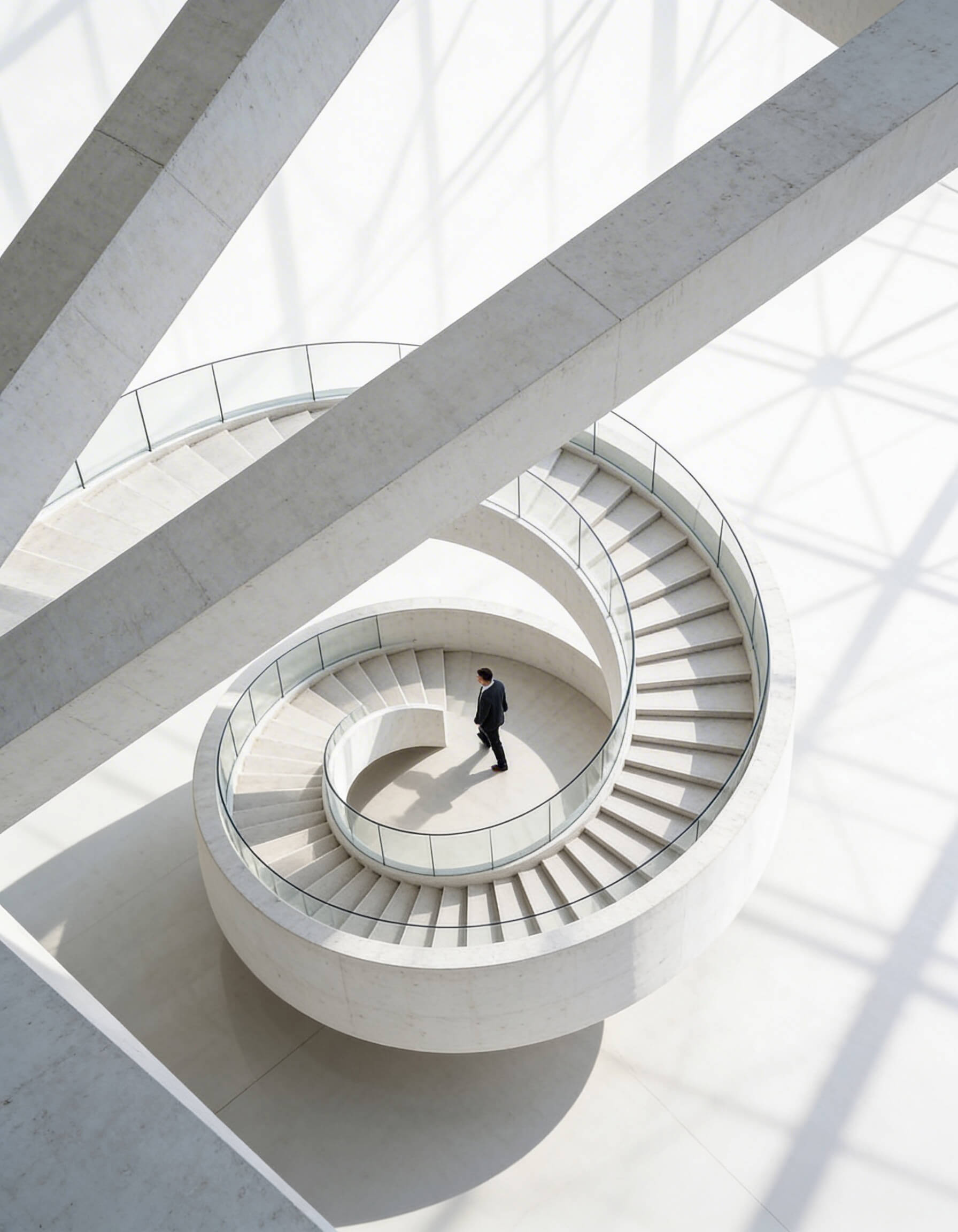 Aerial view of a tight spiral staircase with a lone figure descending