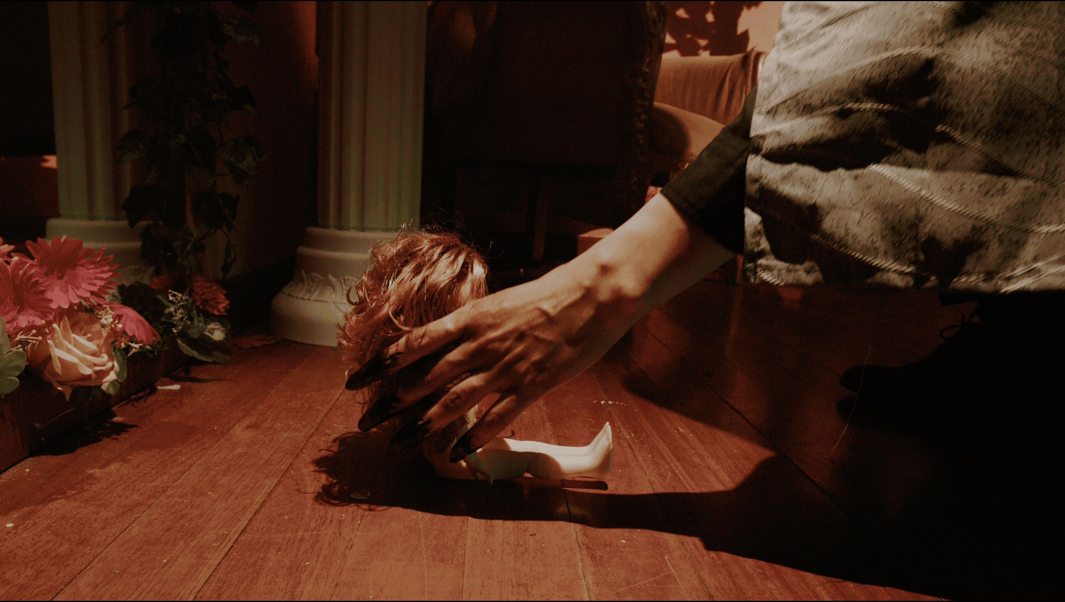 Woman in a light suit sitting thoughtfully against a terracotta wall