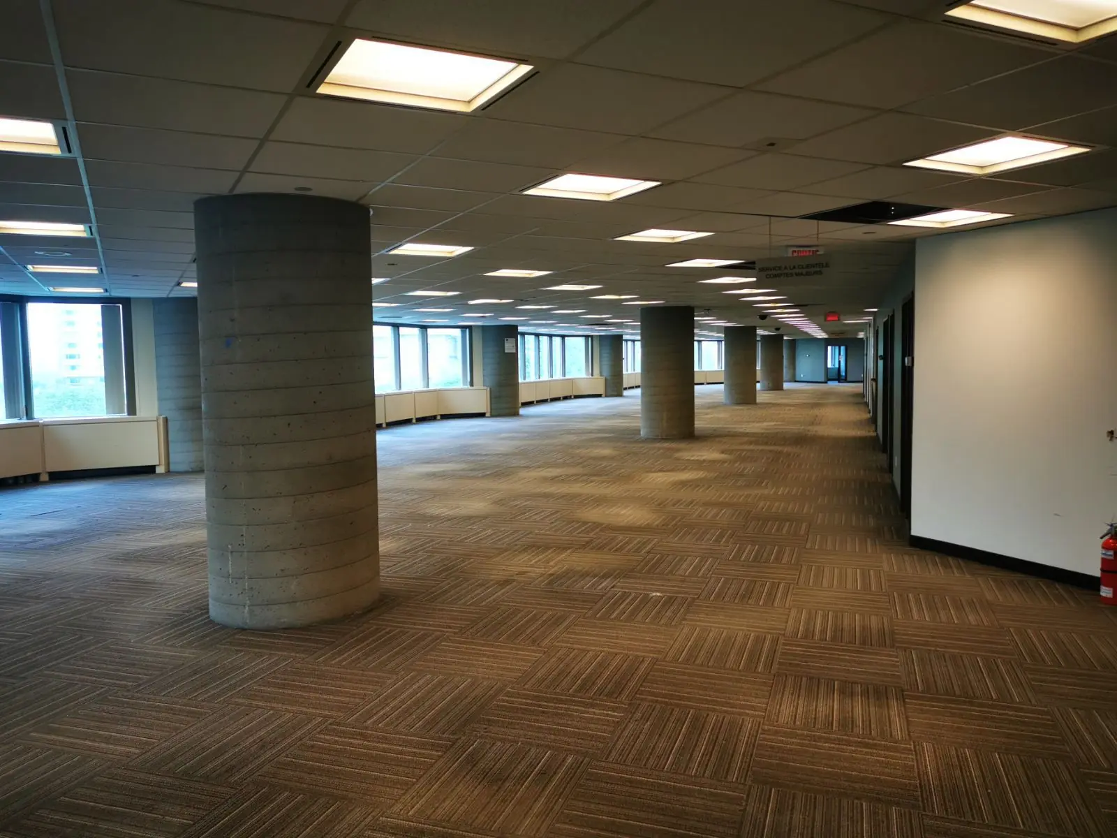 Large empty office space during decommissioning with open floor plan, columns, and cleared commercial interior ready for teardown or transition
