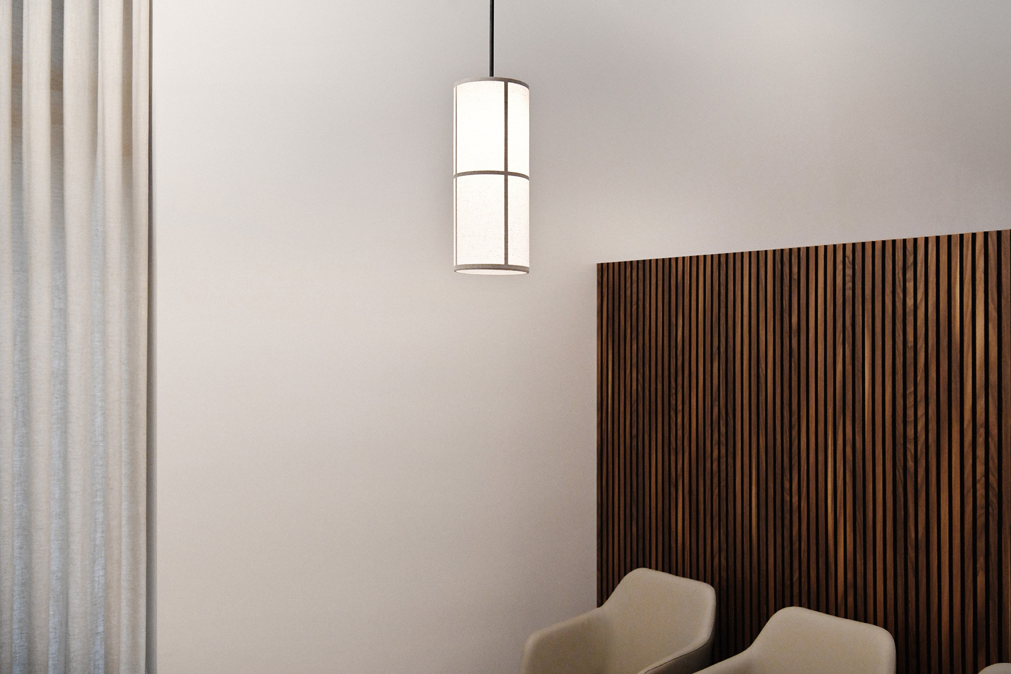 Wartezimmer in der Praxis Spinamed in Muri mit moderner Hängelampe, Holzpaneelwand und zwei hellen Stühlen