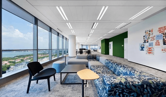 Vibrant Open Office floor with ergonomic desks, blue accents, and a communal meeting table in Boomi.