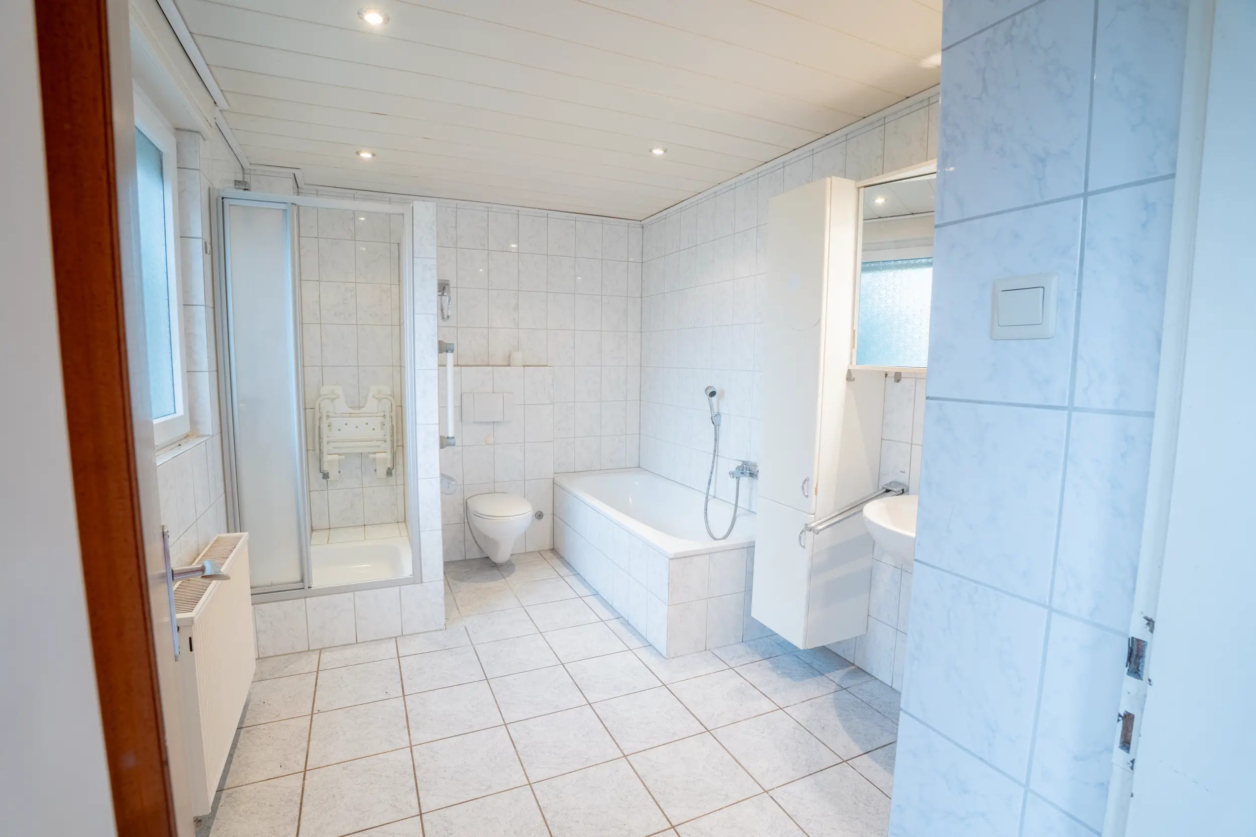 Geräumiges Badezimmer mit Dusche, Badewanne, WC und heller Fliesenausstattung im Einfamilienhaus in Gronau-Epe.