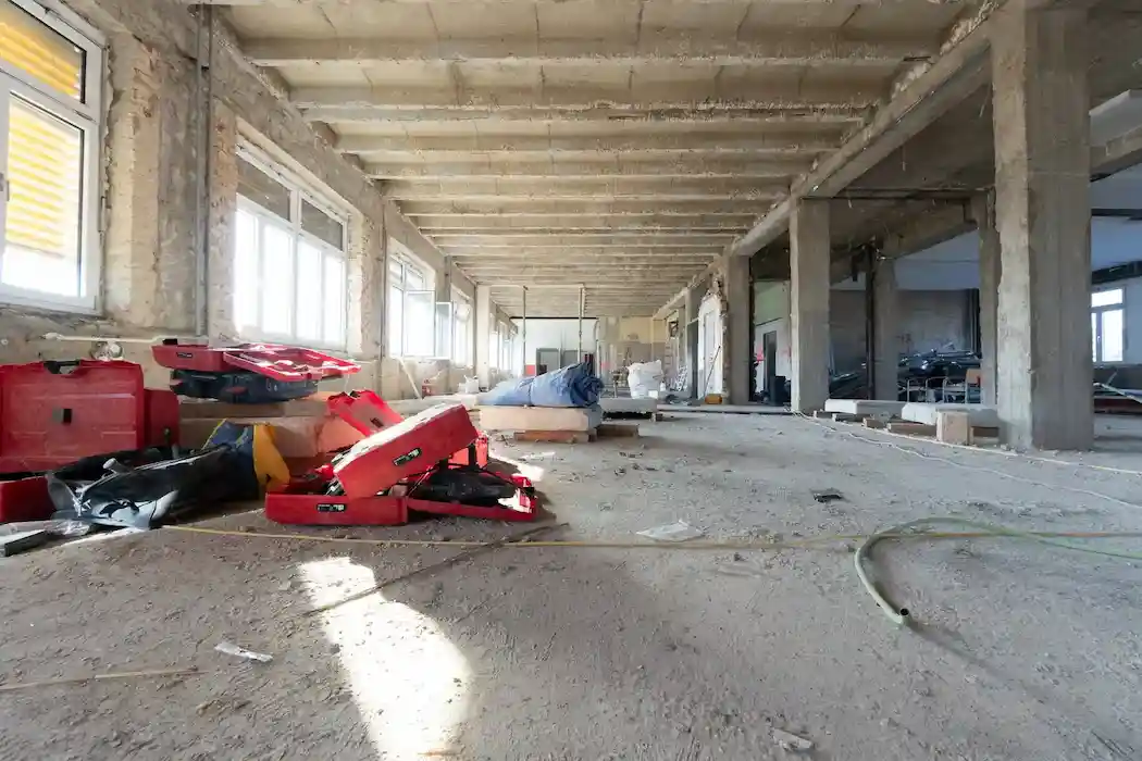 Innenraum im Rückbau mit freigelegter Struktur und Baustellenausrüstung während der Entkernung