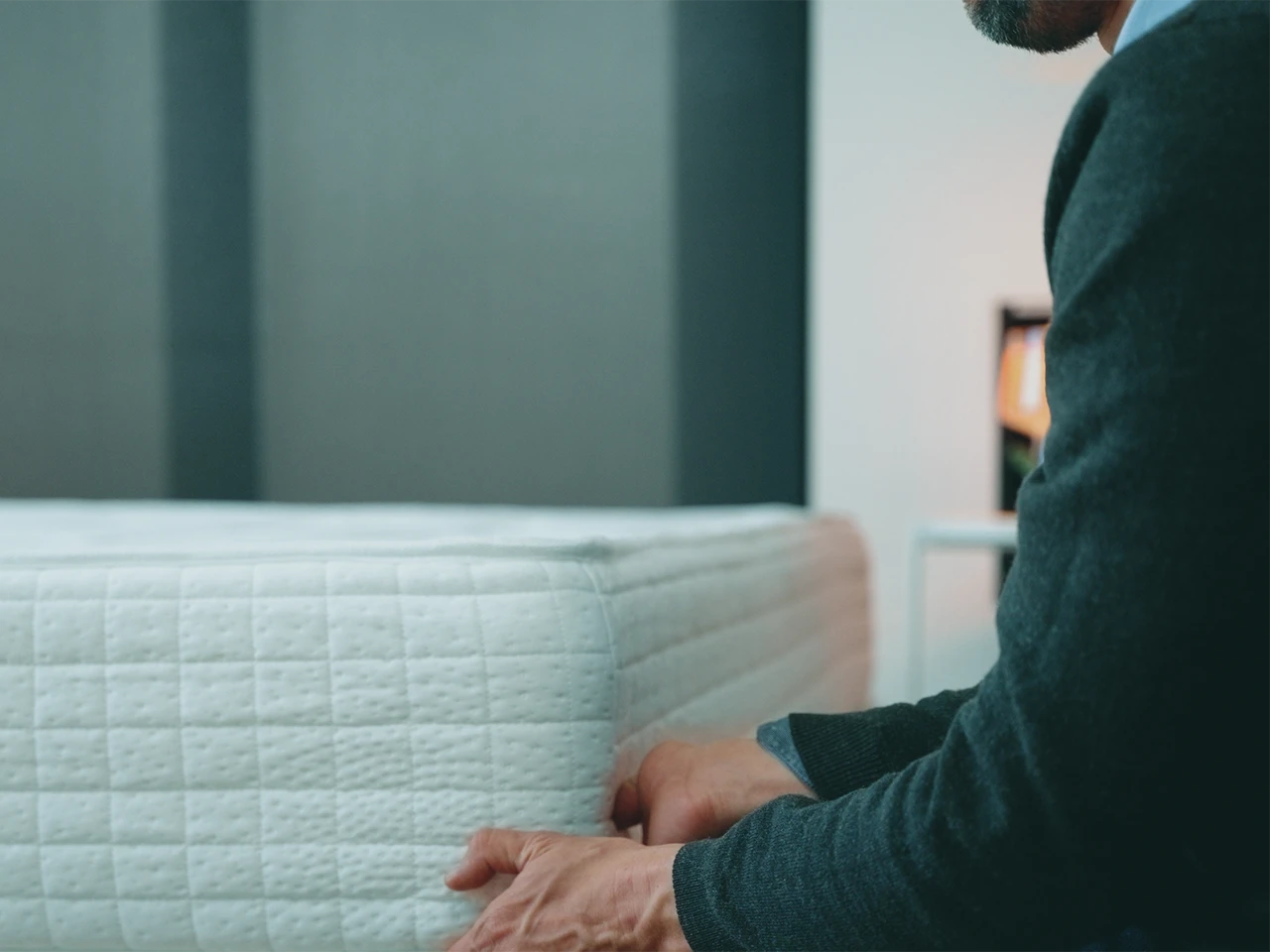 Gros plan d'un homme tenant un matelas par le dessous