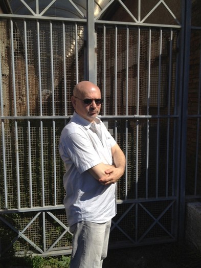 man with glasses in front of gate