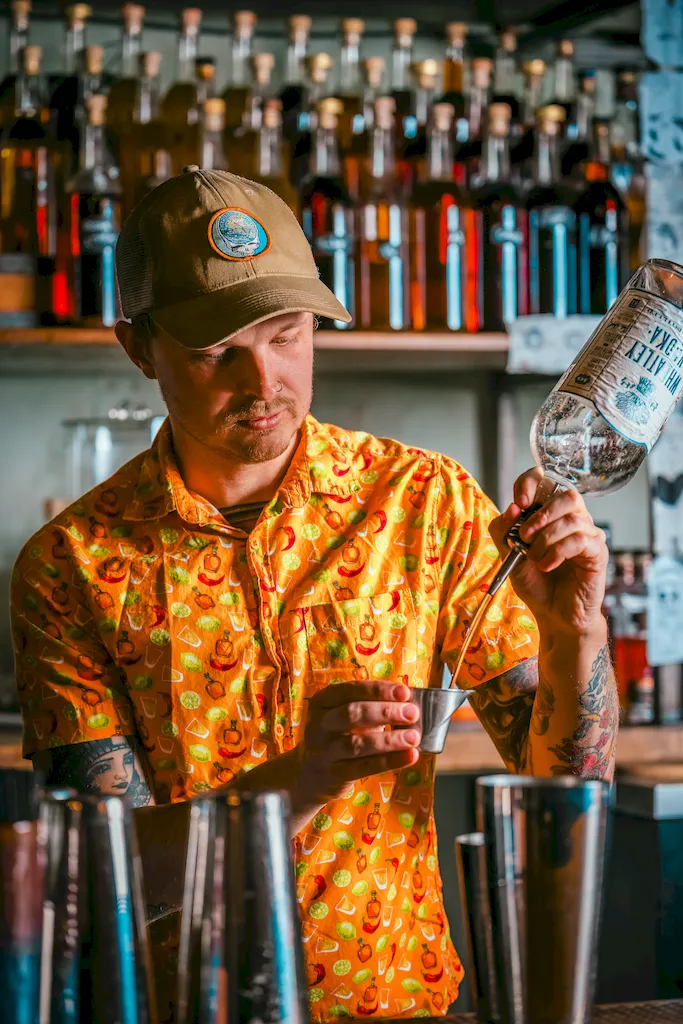 Bartender measuring liquor into a jigger