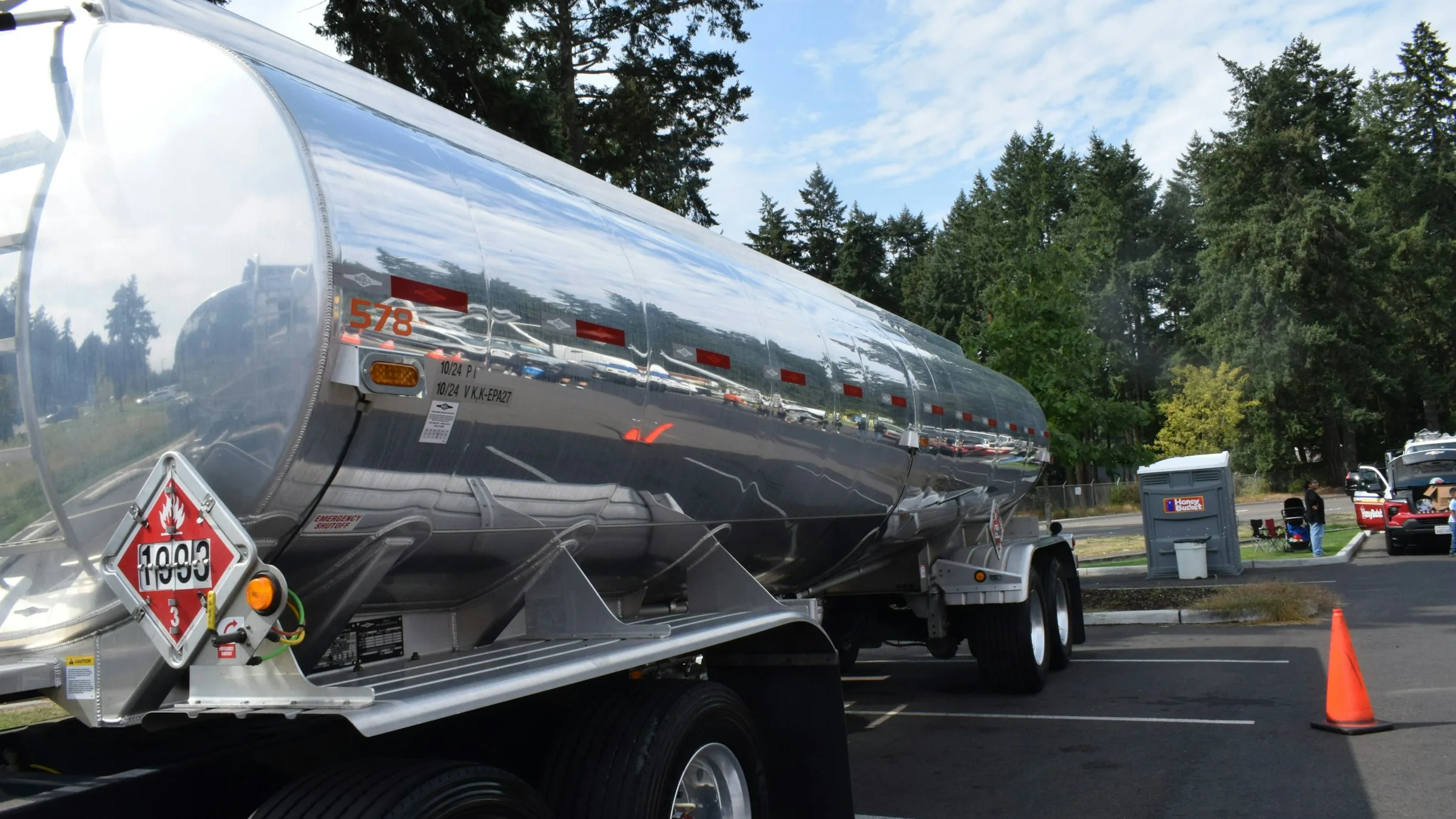 Stainless steel tanker trailer with a hazardous materials placard parked at a depot