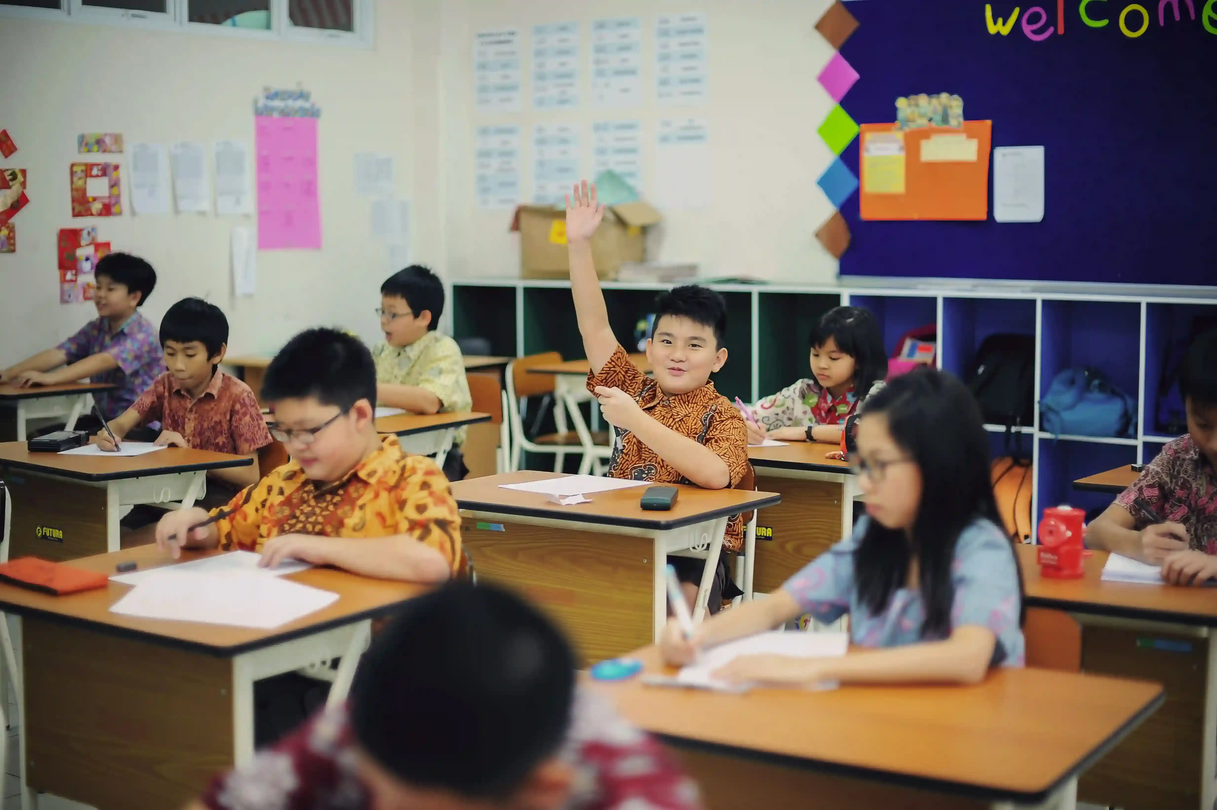 Students actively participating in a classroom lesson at a tuition centre in Singapore, demonstrating an engaging and supportive learning environment.