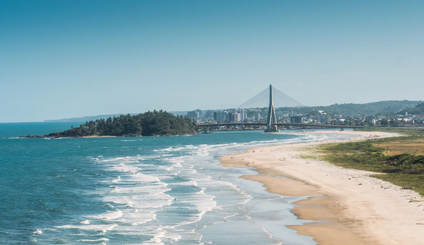 Vista aérea da praia tranquila em Ilhéus com mar azul e areia clara