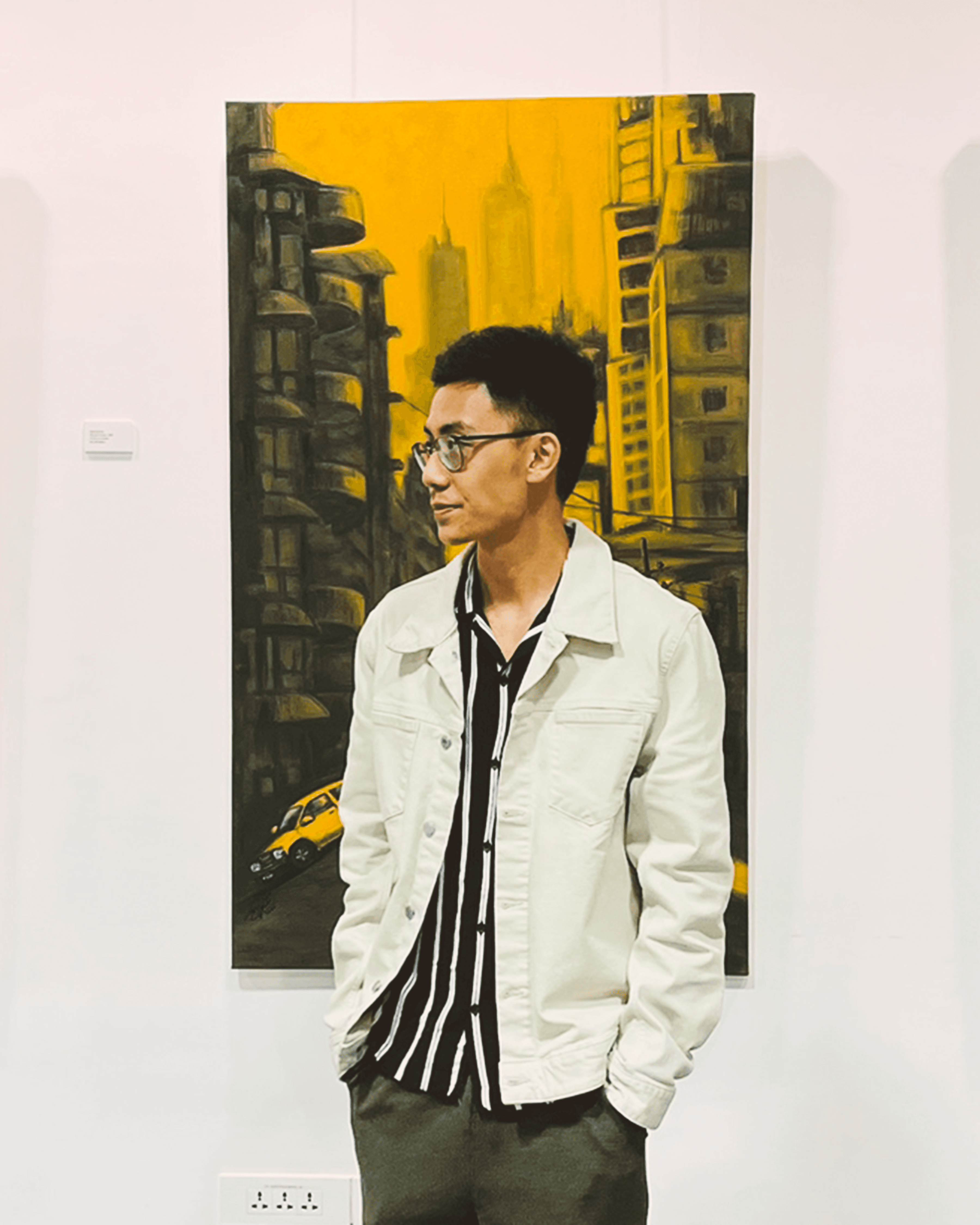 A thoughtful young person with dark hair gazes to the side, captured in soft black and white lighting.
