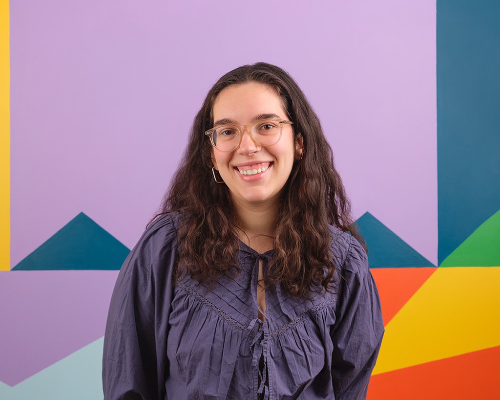 Portrait of Cecilia Salcedo standing in front of a colourful mural