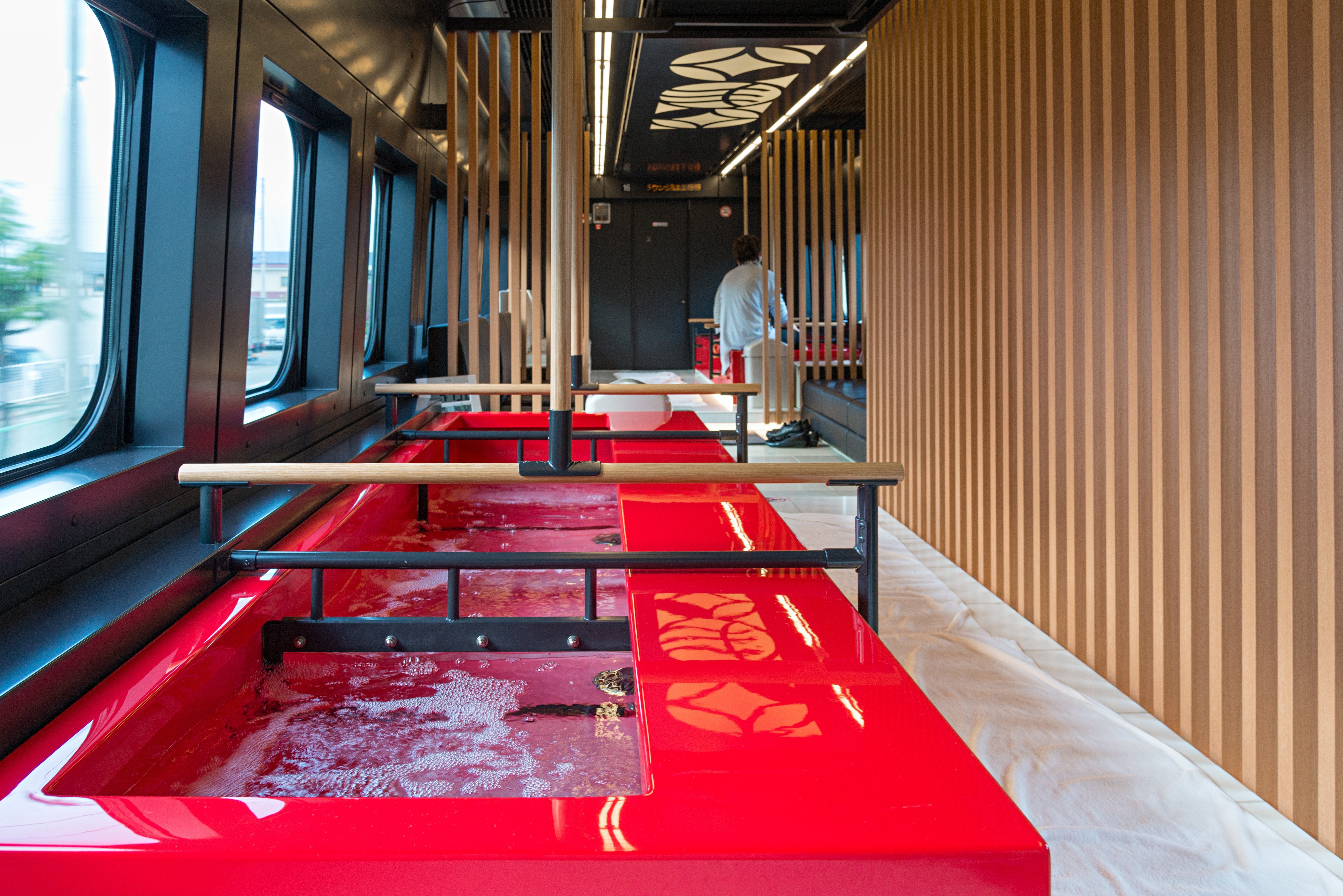 Water bubbles in red hot tubs built into a Japanese train.