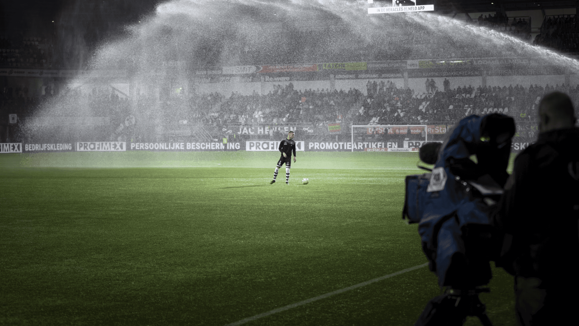 A wide shot of a footbal field with a single player