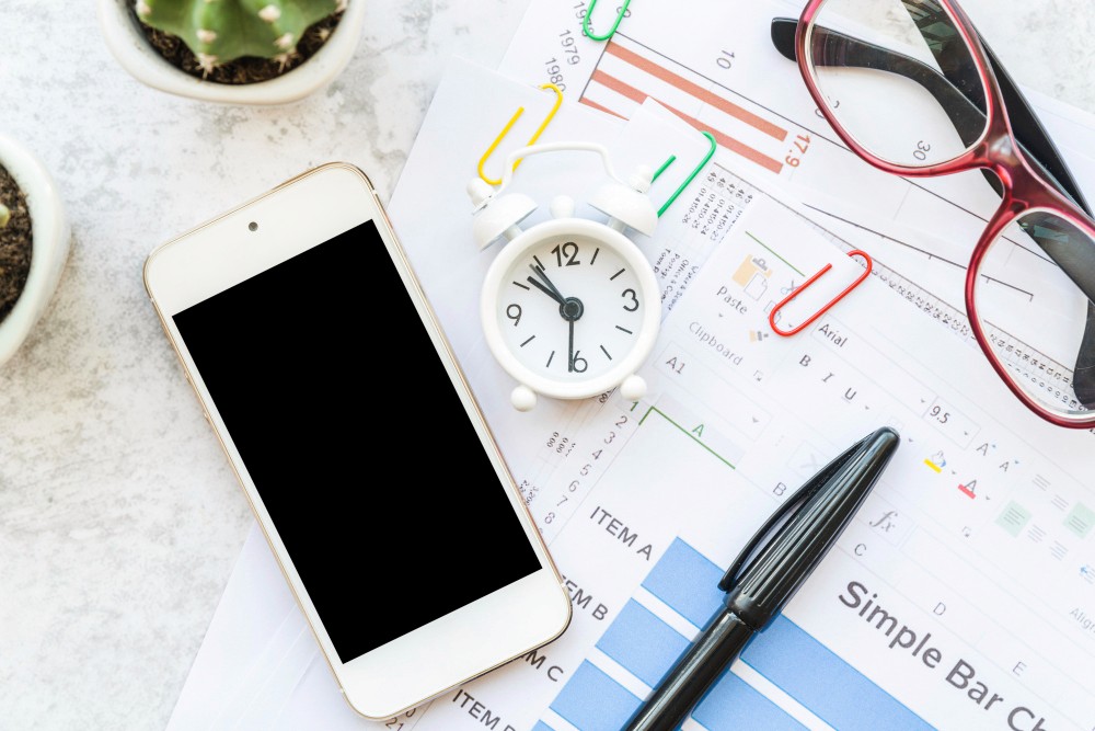 Workspace with stationery and papers with smartphone